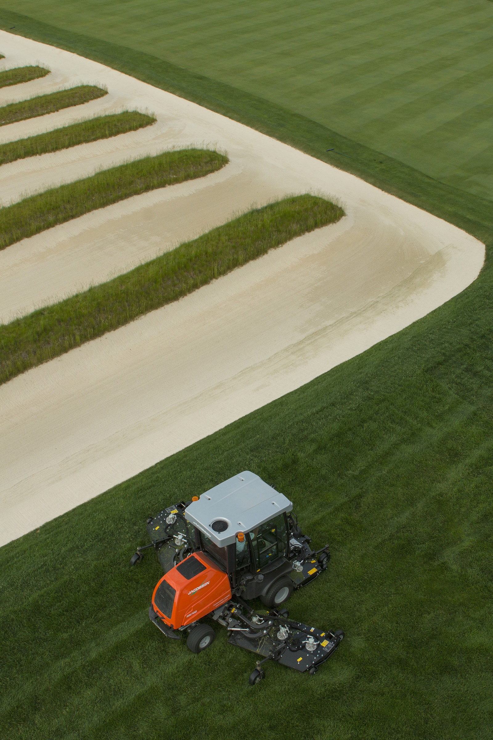 Una máquina rotativa de Jacobsen para áreas amplias HR700 manteniendo el rough de 4.5 pulgadas cerca de los afamados bancos de iglesia de Oakmont, una característica del campo que el superintendente John Zimmers mantiene en perfectas condiciones todo el año para los visitantes.